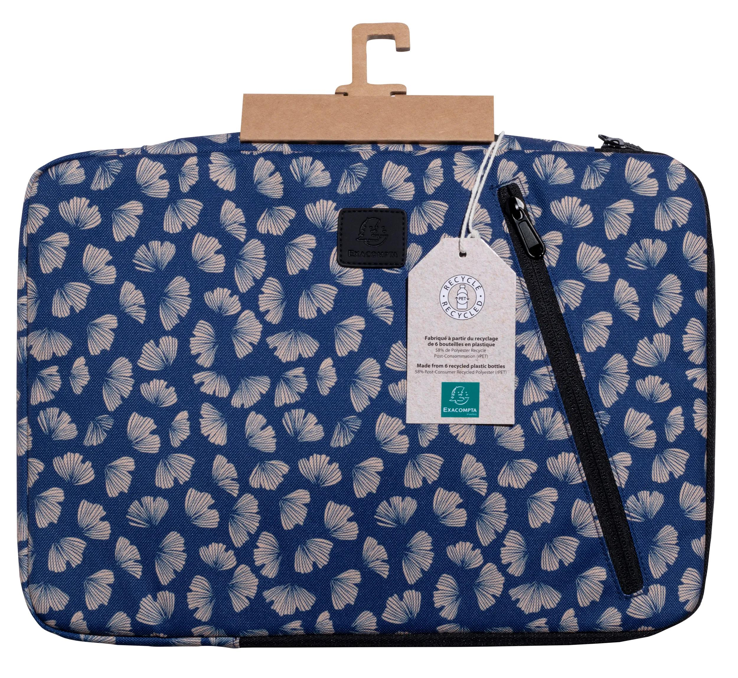 Borsa blu con motivo a foglie, etichetta, cerniera e manico marrone.