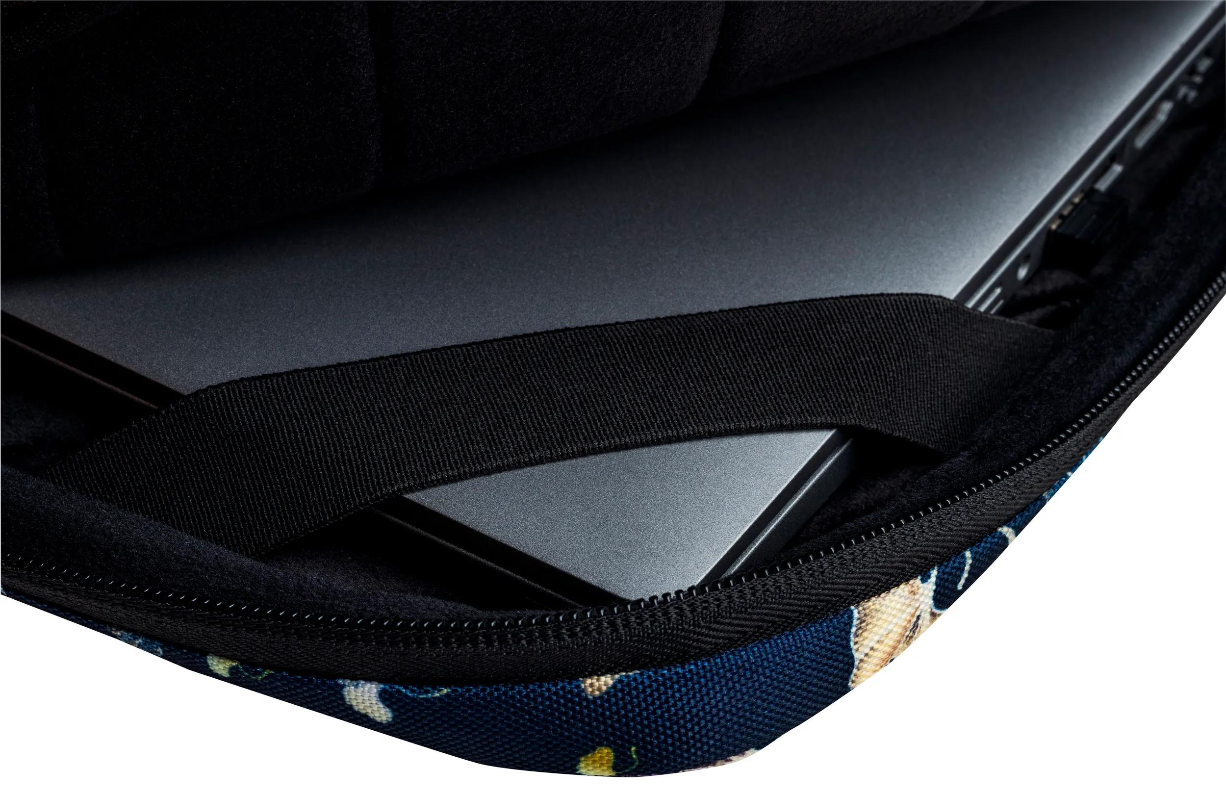 Un laptop in una custodia. La custodia è nera con un esterno blu a fantasia. È visibile una cinghia nera.