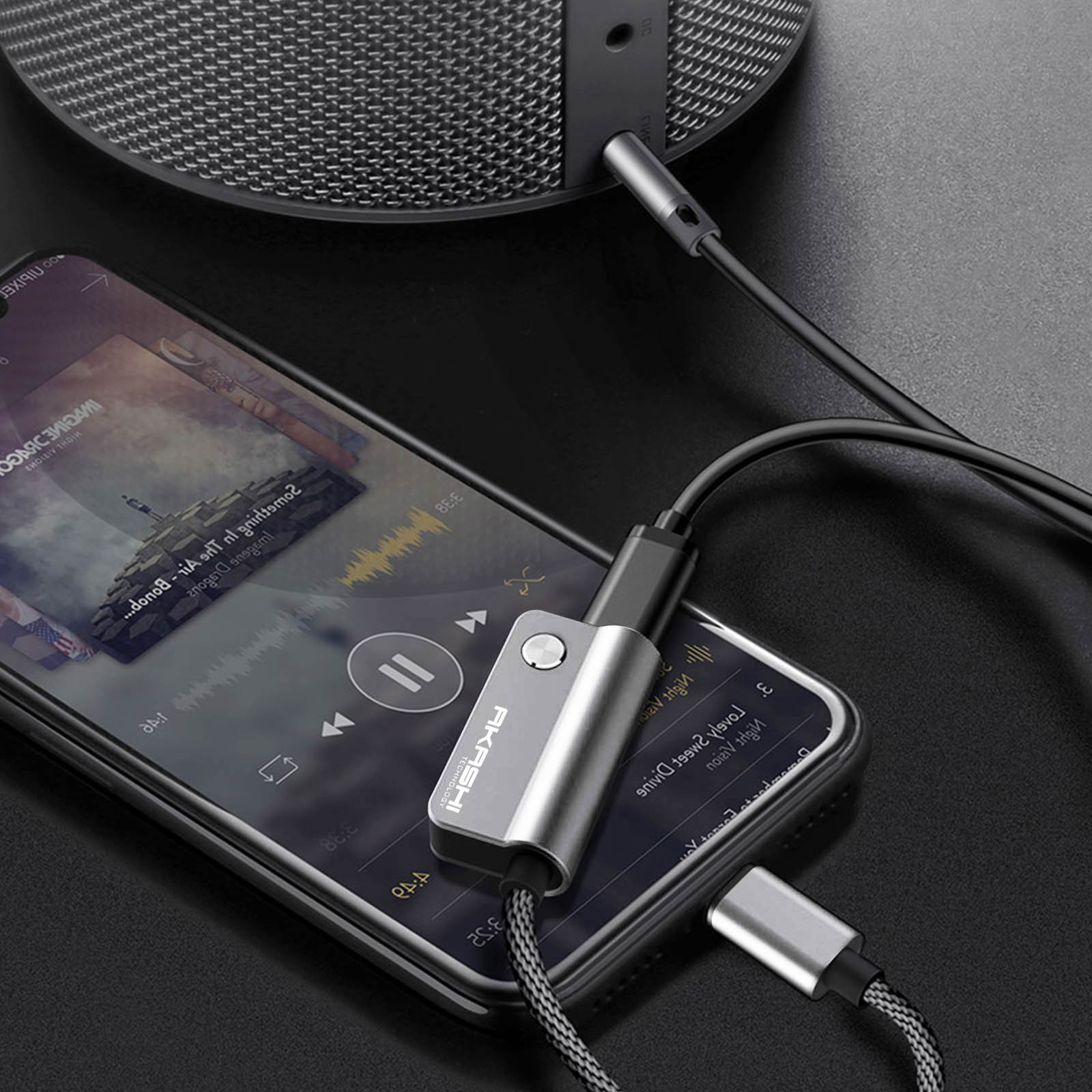 Téléphone avec application musicale connecté à un haut-parleur via un adaptateur audio. L'adaptateur est connecté à un haut-parleur. Fond noir.