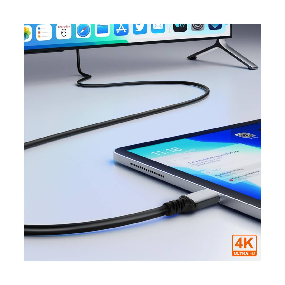 Ein Tablet ist über ein schwarzes Kabel mit einem Fernseher verbunden. Das Tablet zeigt einen Kalender an. Der Fernseher zeigt App-Symbole.