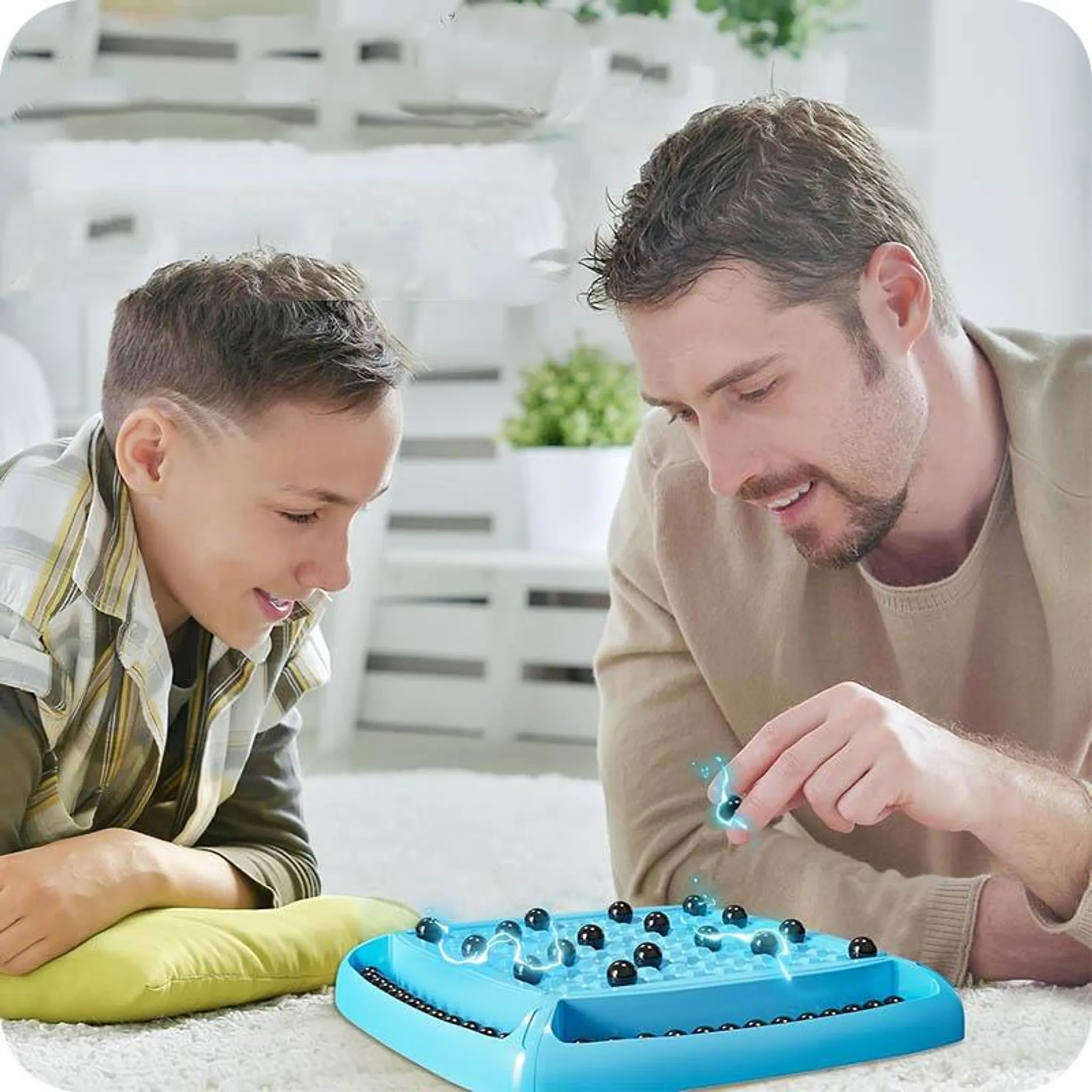 Ein Mann und ein Junge spielen ein Brettspiel mit schwarzen Kugeln. Das Spiel ist blau. Sie lächeln.