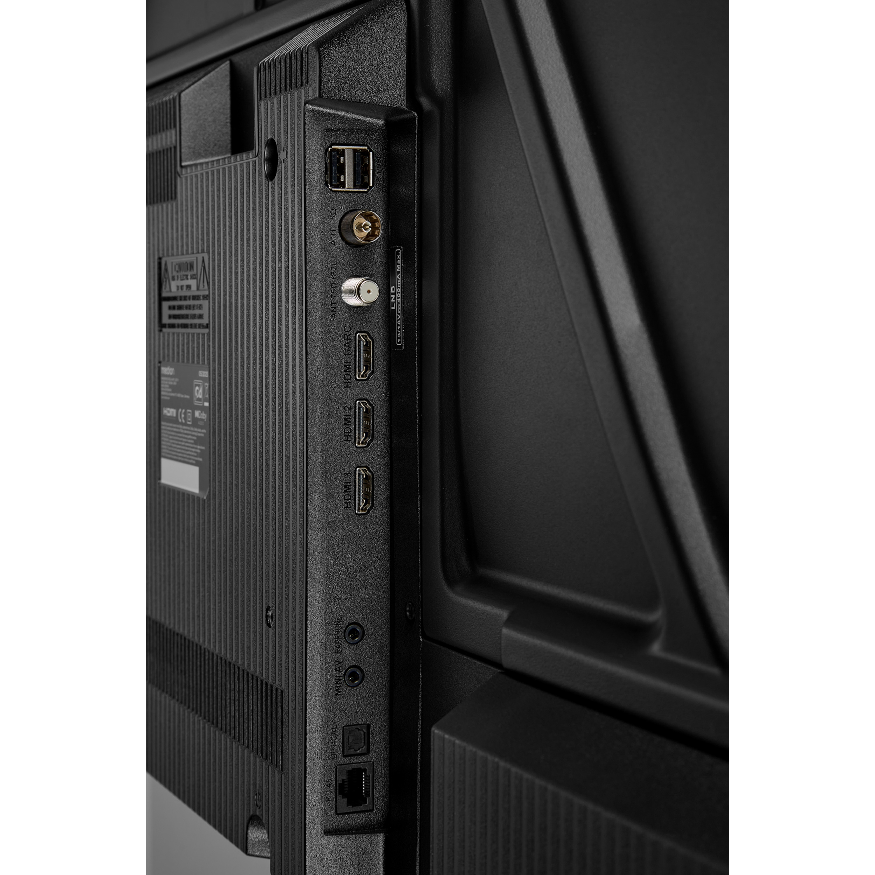 Close-up van de achterkant van een zwarte tv met diverse poorten: USB, HDMI, antenne en audio-uitgangen.