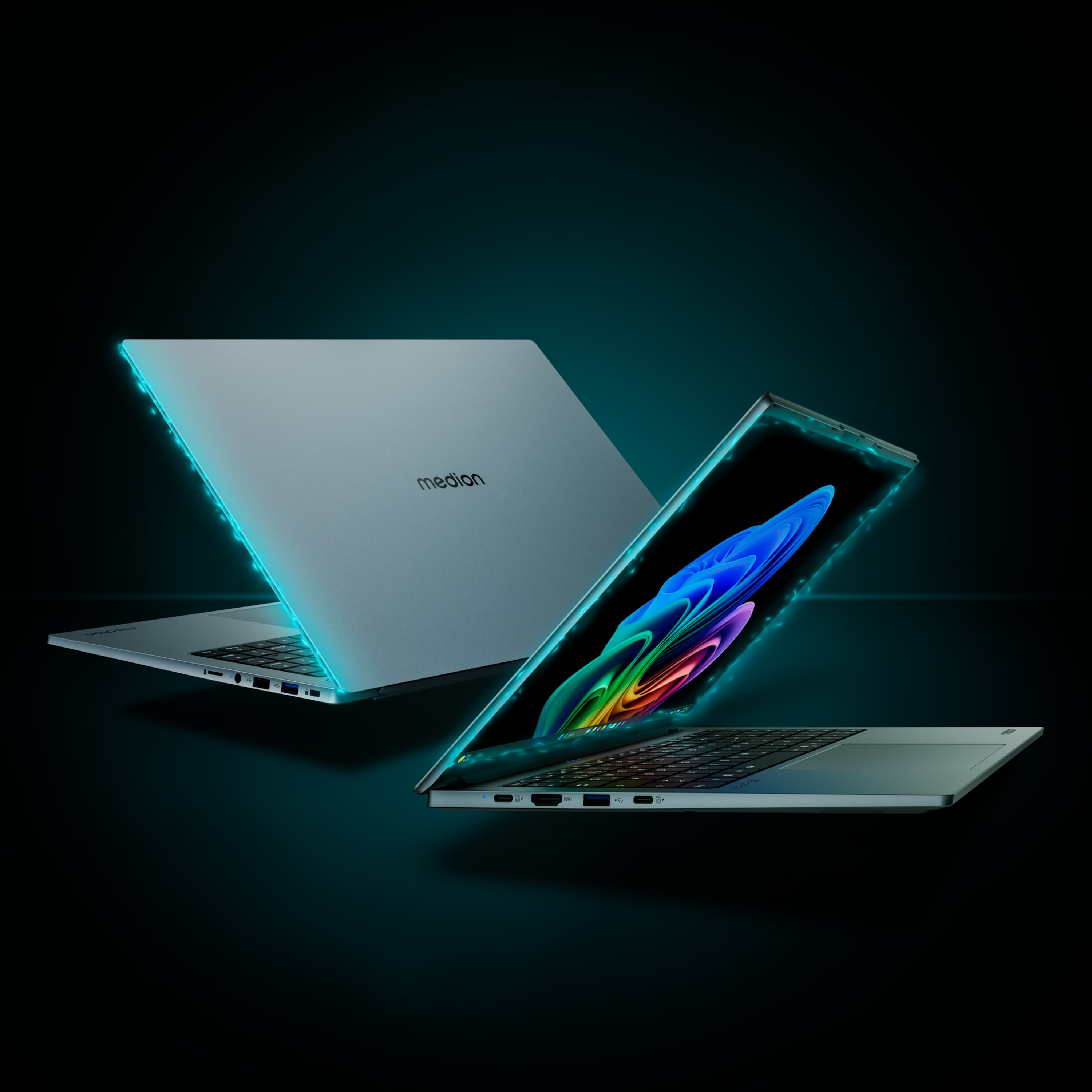 Zwei Laptops, einer offen mit farbenfroher Anzeige, der andere geschlossen, beide mit blau leuchtenden Kanten, auf Schwarz.