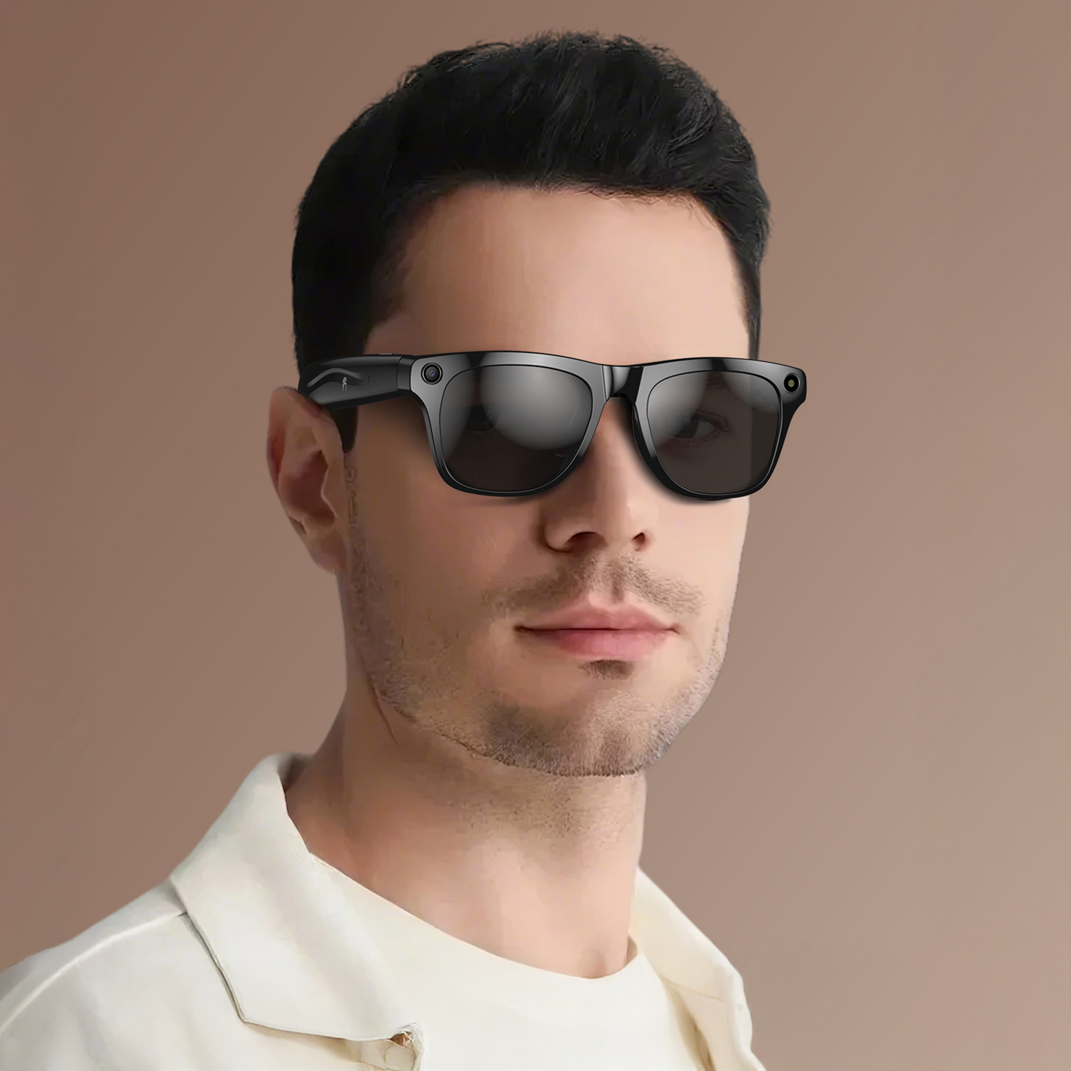 Un uomo con occhiali da sole intelligenti neri. Ha i capelli scuri, una camicia bianca e si trova su uno sfondo marrone.