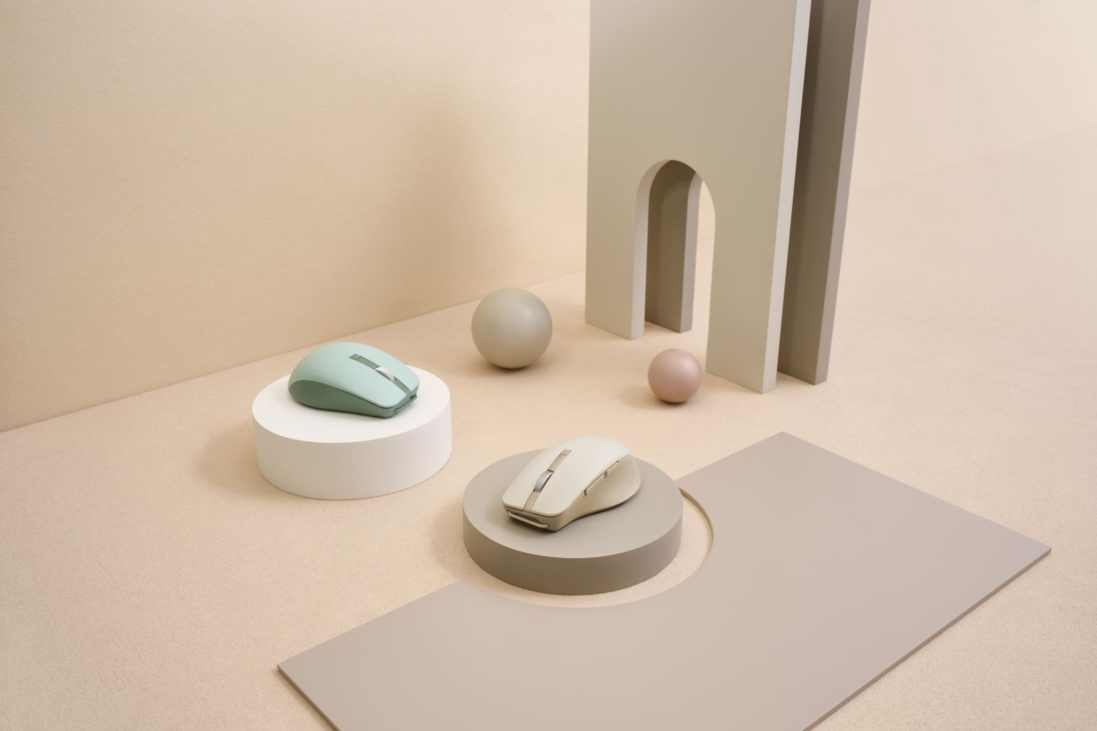 Een artistieke compositie met twee computermuizen, bollen en geometrische vormen, allemaal in pastelkleuren, wat een minimalistische esthetiek creëert.