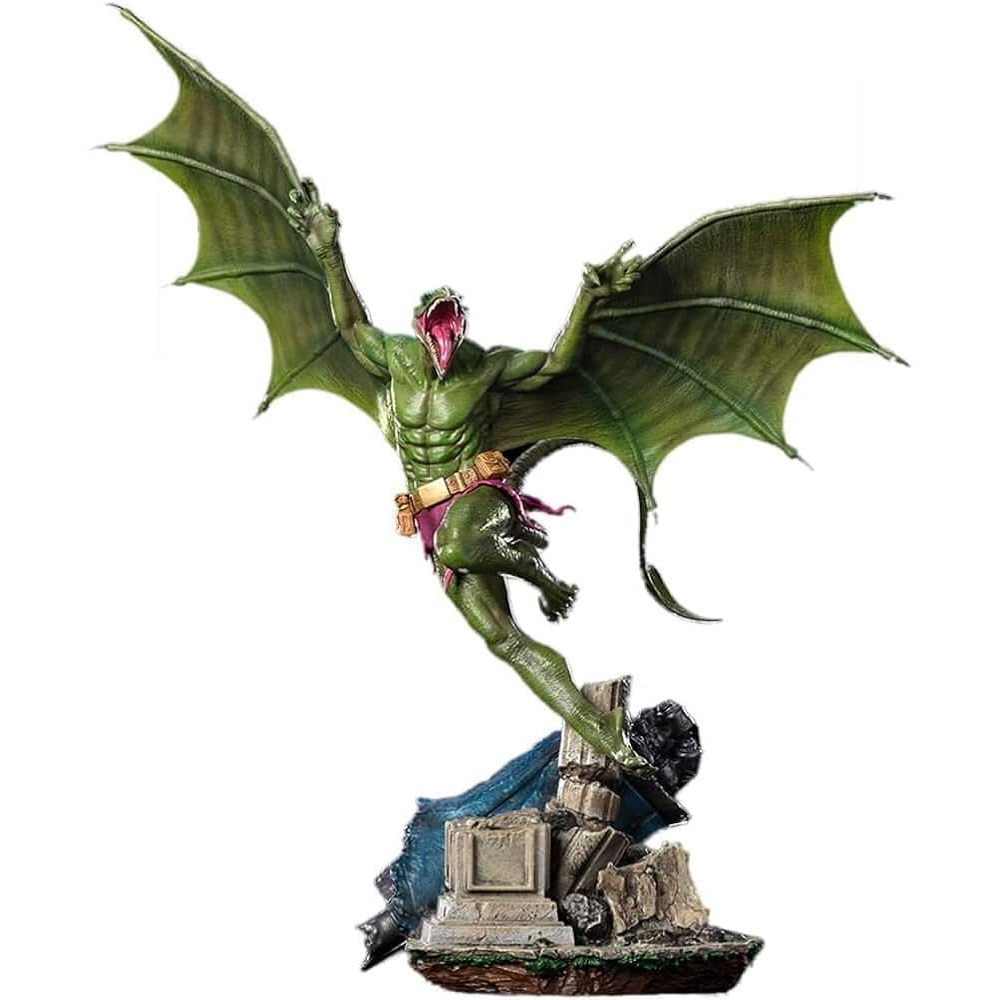 Statua di mostro verde con grandi ali e bocca aperta, in piedi su una base di pietra con tessuto blu. È una figura di fumetto.