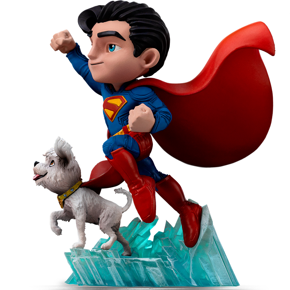 Statuina di Superman che vola con un cane bianco. Superman indossa un costume blu, un mantello rosso e stivali. Il cane ha un collare giallo.