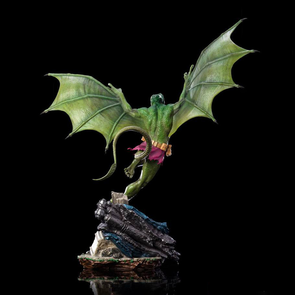 Una figura verde simile a un drago con grandi ali è raffigurata in volo, su una struttura rocciosa contro uno sfondo nero.