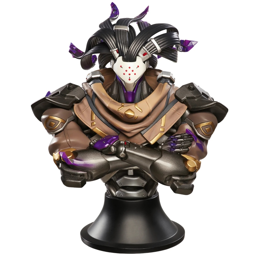 Un busto di un robot con le braccia incrociate. Ha un mantello marrone chiaro, capelli neri e accenti viola. Si trova su una base nera.