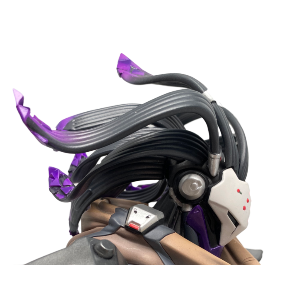 Primo piano della testa di una figura futuristica. Presenta strutture nere simili a capelli con accenti viola. Maschera bianca con punti rossi e visiera viola.