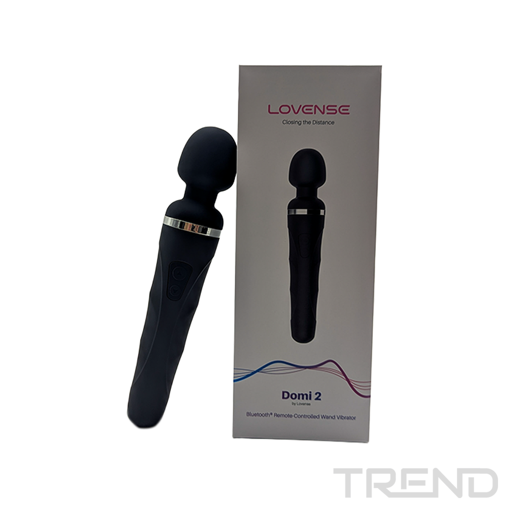 Czarny masażer w kształcie różdżki i jego pudełko na białej powierzchni. Na pudełku napis "Domi 2" i "Lovense". Masażer obok pudełka.
