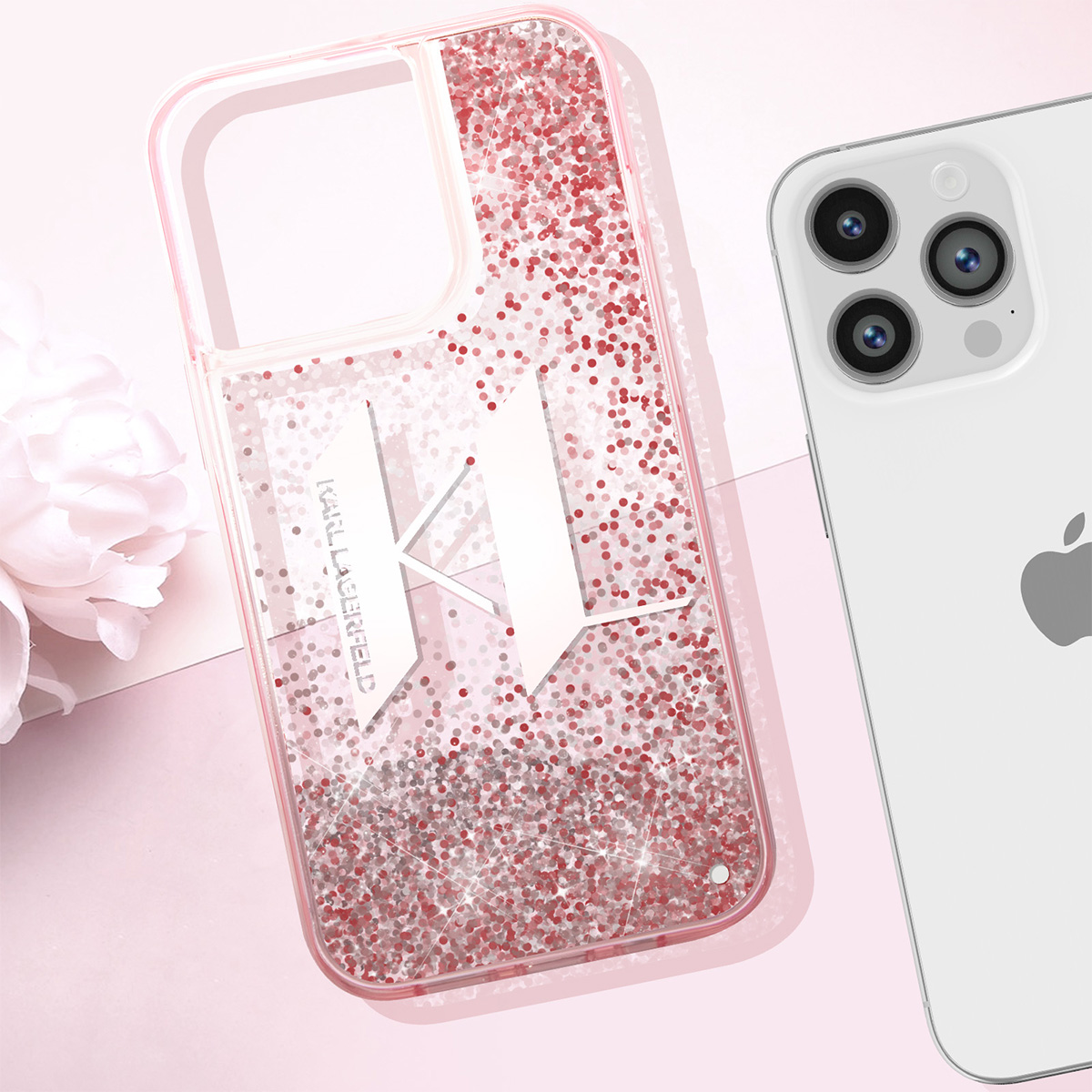 Una custodia per telefono con glitter e logo 'K' è accanto a un iPhone bianco. Un fiore è sullo sfondo. Lo sfondo è rosa.