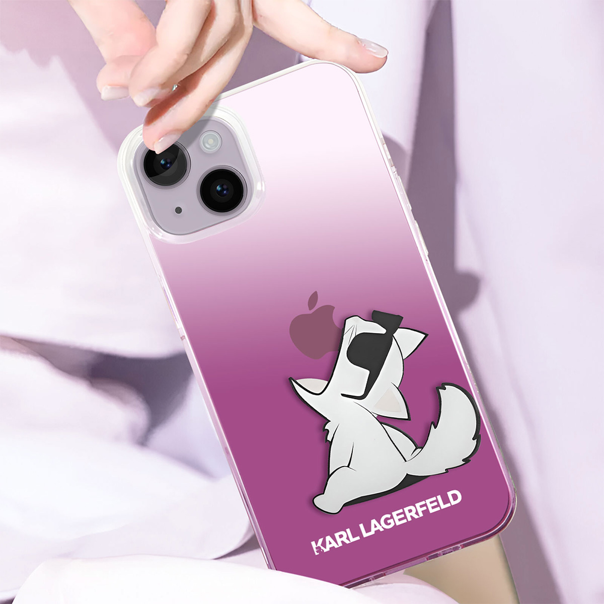 Una mano che tiene una custodia per telefono con un design Karl Lagerfeld. Presenta un gatto bianco dei cartoni animati su uno sfondo viola sfumato.