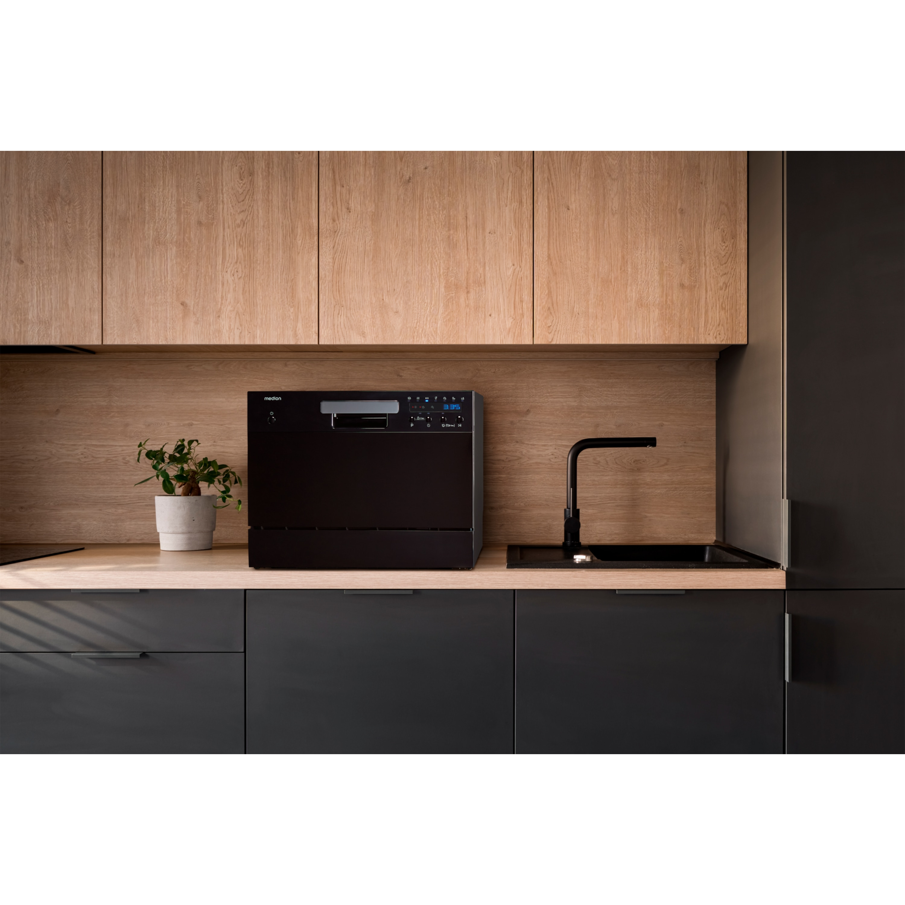 Cucina moderna con lavastoviglie, lavandino e armadi neri. Mobili e piano di lavoro in legno.