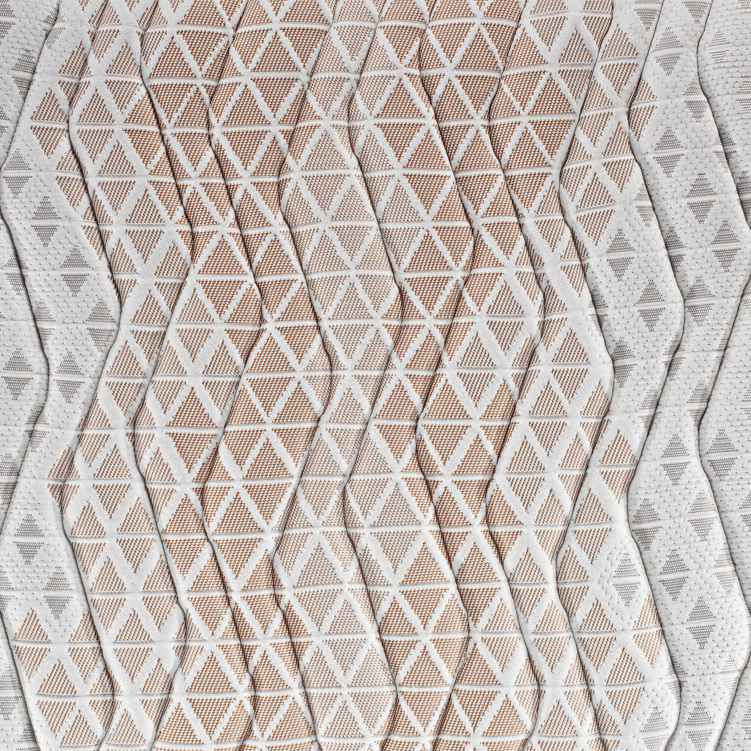 Primer plano de una tela estampada blanca y marrón. El patrón incluye triángulos y líneas onduladas creando una superficie texturizada.