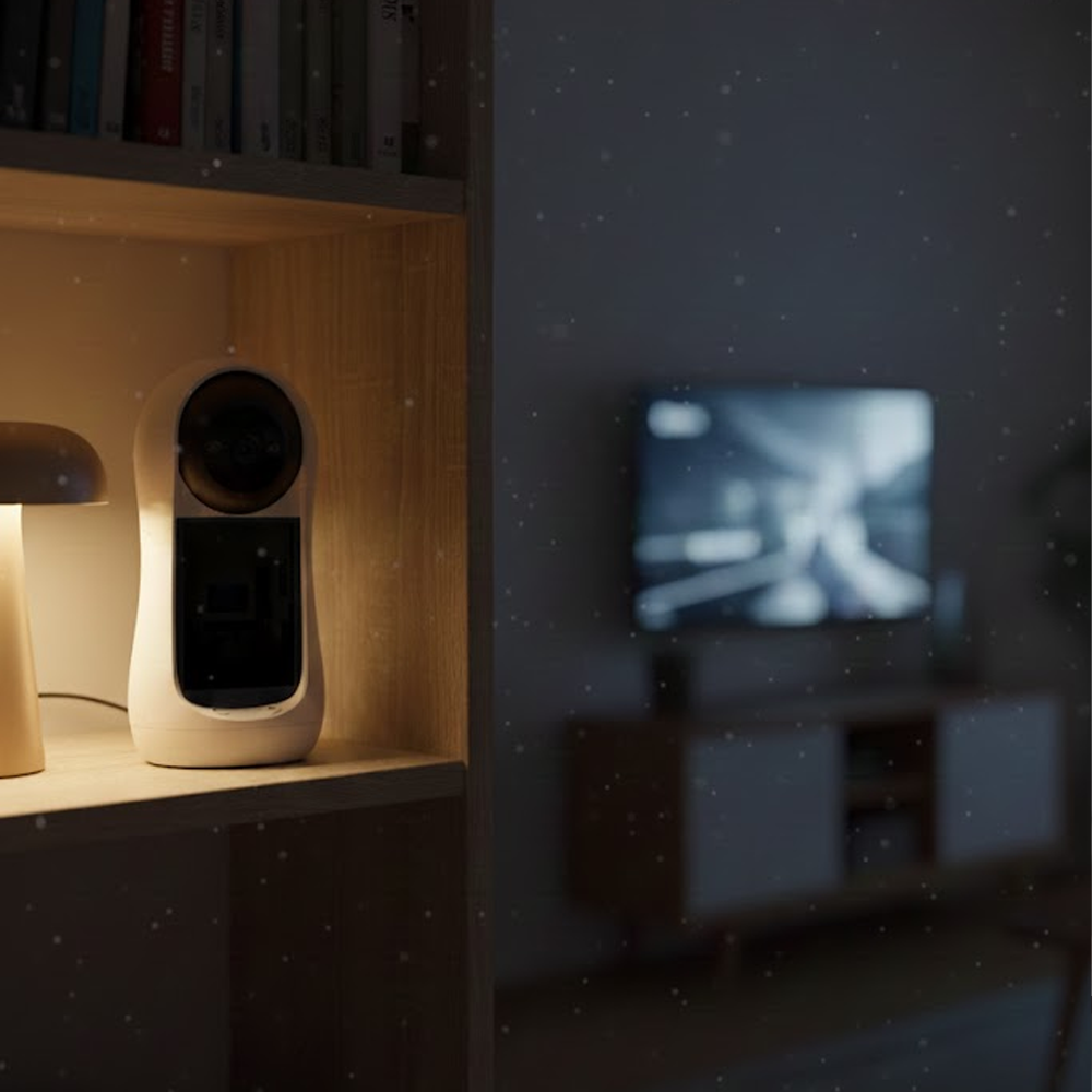 Bir rafta beyaz bir güvenlik kamerası. Solda bir lamba var. Arka planda bulanık bir TV ve altında bir dolap.