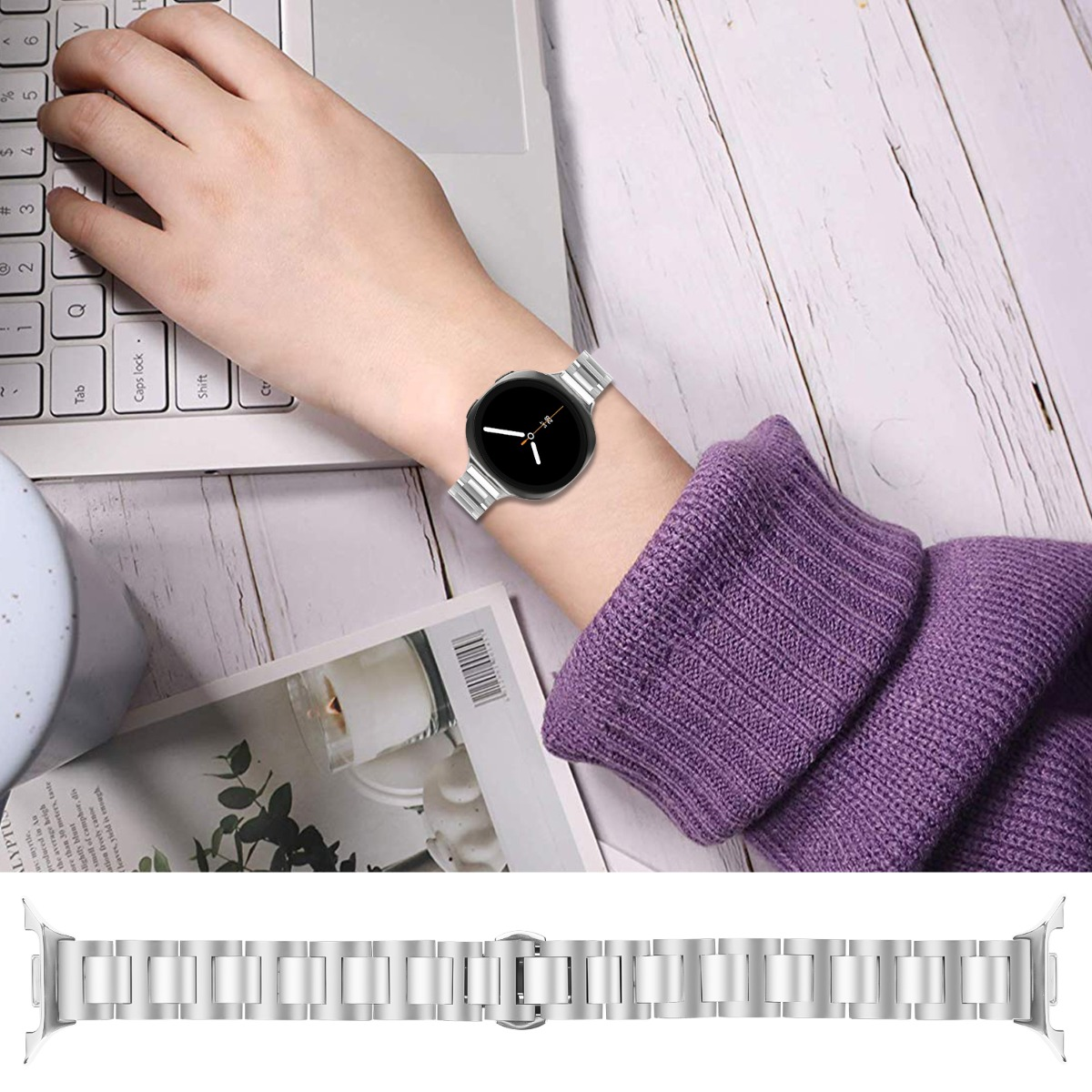 Eine Person, die eine silberne Uhr am Handgelenk trägt, tippt auf einem Laptop. Ein silbernes Uhrenarmband befindet sich unter dem Handgelenk.