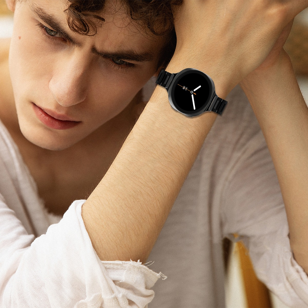 Un uomo con uno smartwatch nero al polso. Indossa una camicia bianca e guarda in basso. L'orologio ha le lancette bianche.