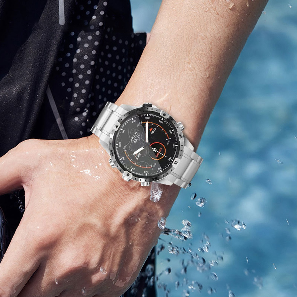 Un polso con un orologio d'argento è parzialmente immerso nell'acqua. Il quadrante è nero con segni bianchi e accenti arancioni.