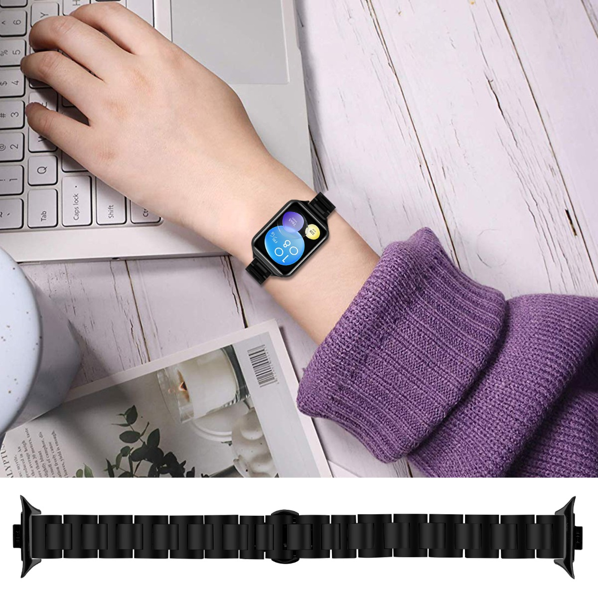 Una persona lleva un reloj inteligente en la muñeca. Una computadora portátil, una revista y una taza están sobre la mesa de madera.