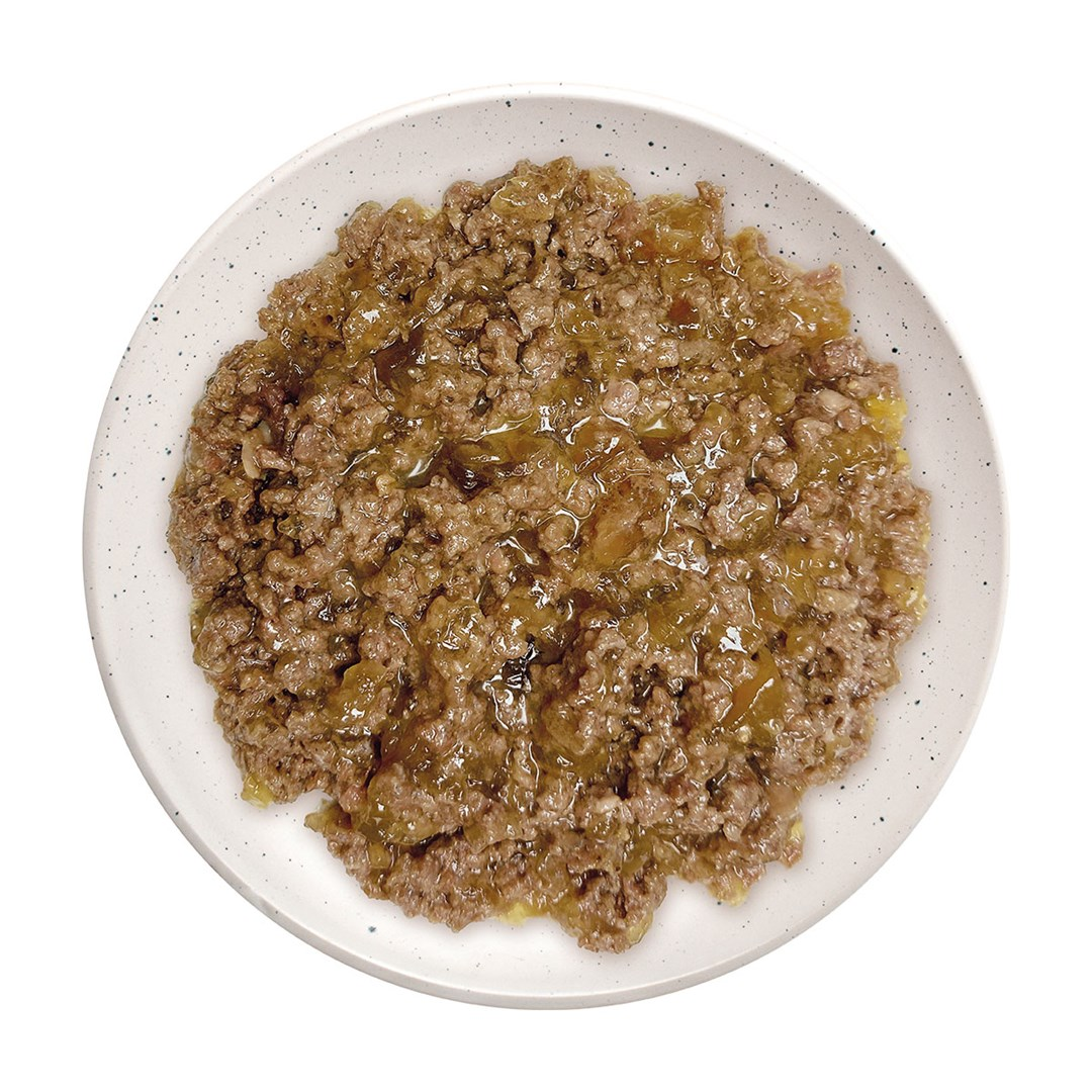Biały talerz wypełniony brązowym, mielonym mięsem i przezroczystym, lekko żółtawym sosem. Talerz ma ciemne plamki na obrzeżu.