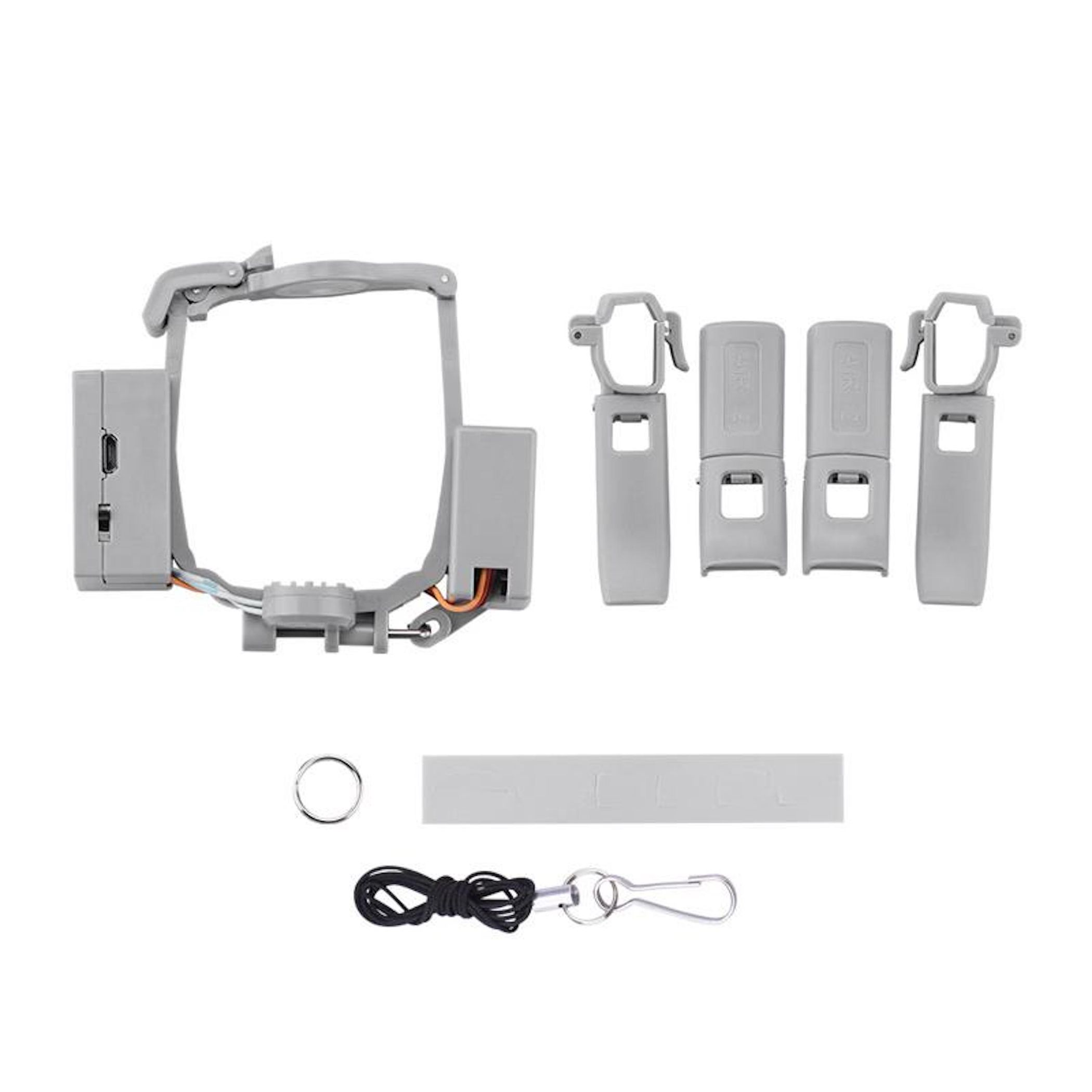Graue Drohnenteile auf weißer Oberfläche angeordnet. Enthält einen Rahmen, Clips, einen Kreis, ein Schlüsselband und einen Streifen.
