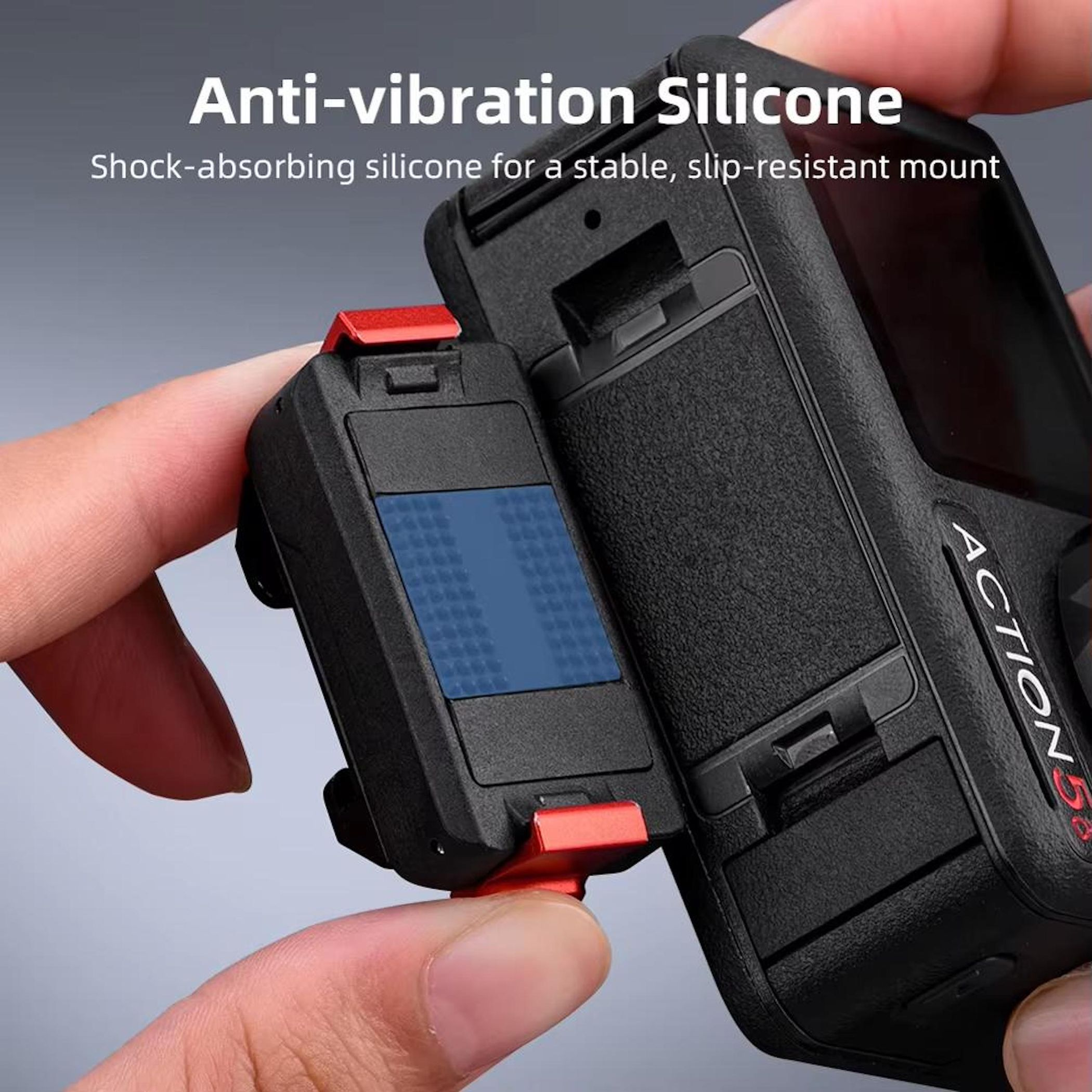 Eine Hand hält eine schwarze Silikonhalterung für eine Action-Kamera. Rote Clips und blaue Pads sind sichtbar.