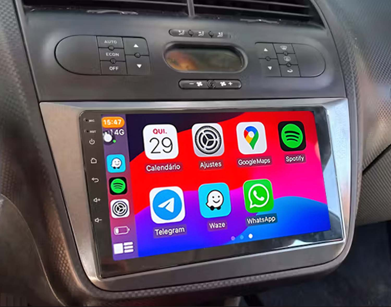 Panel del coche con pantalla táctil que muestra iconos de aplicaciones para calendario, mapas, Spotify y aplicaciones de mensajería.