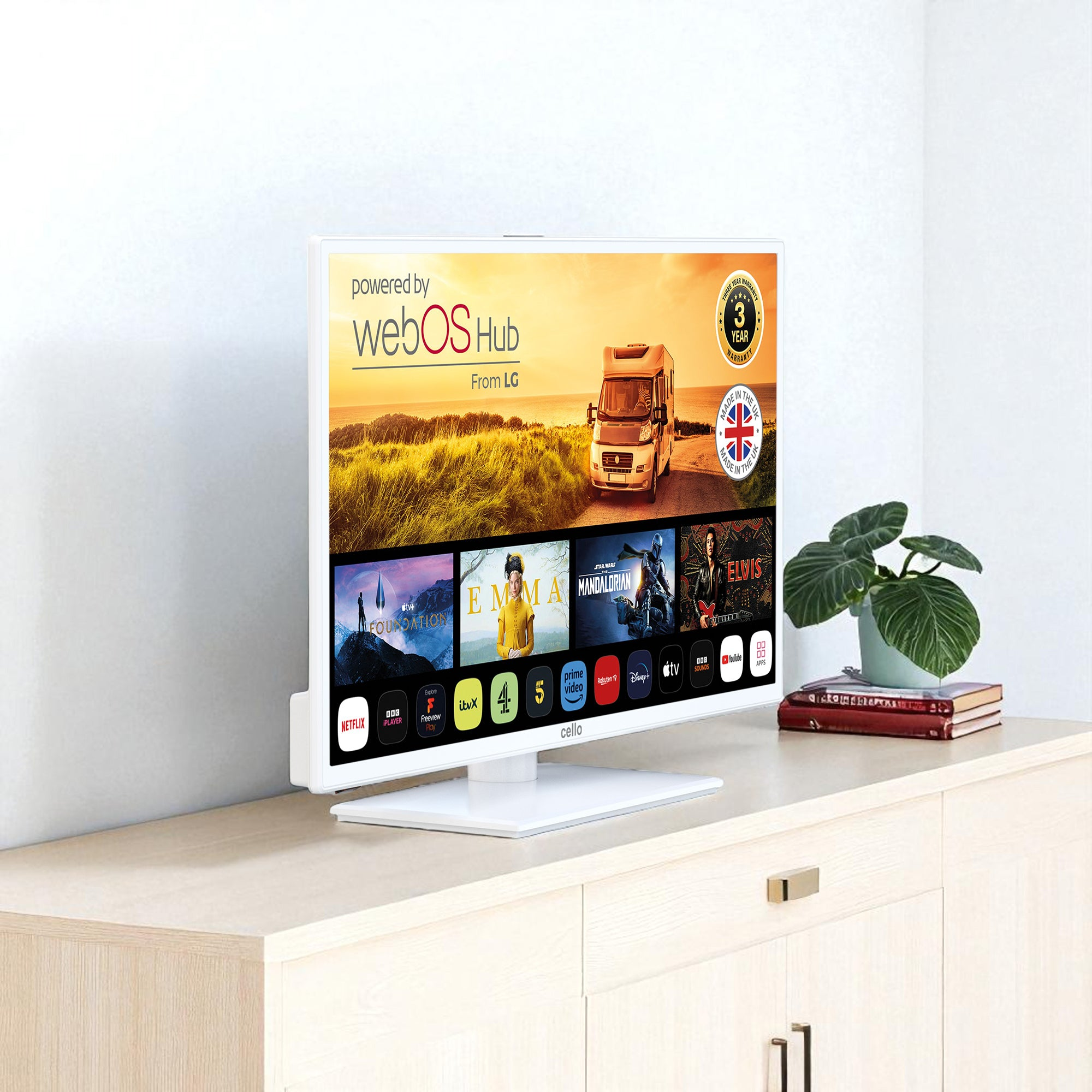 Weißer Fernseher zeigt Streaming-Apps. Unten befinden sich eine Pflanze, Bücher und ein Schrank. Der Bildschirm zeigt einen Camper und Filmtitel.
