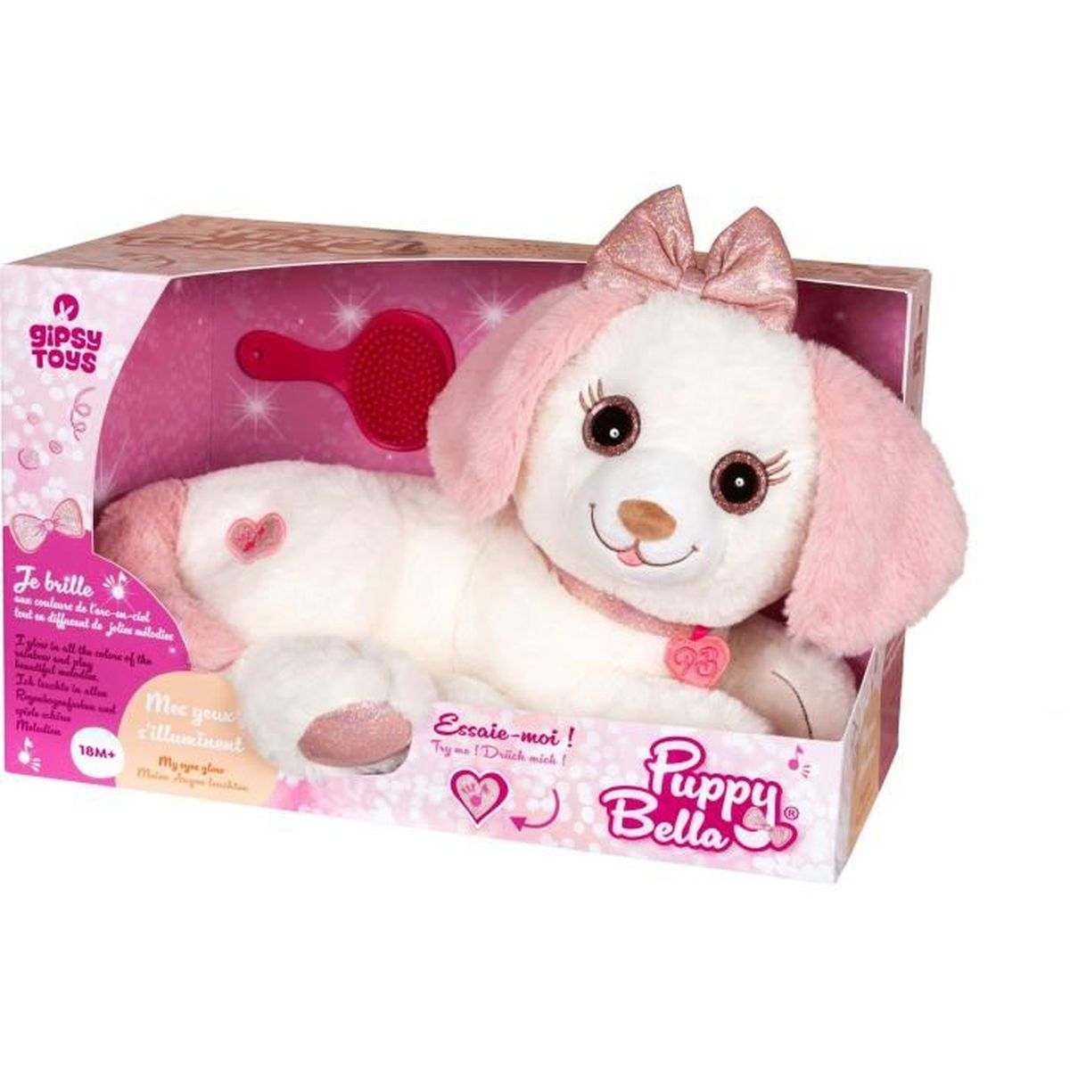 Un jouet Puppy Bella blanc et rose dans une boîte. Il a des oreilles roses, un nœud et un cœur. Une brosse est incluse.