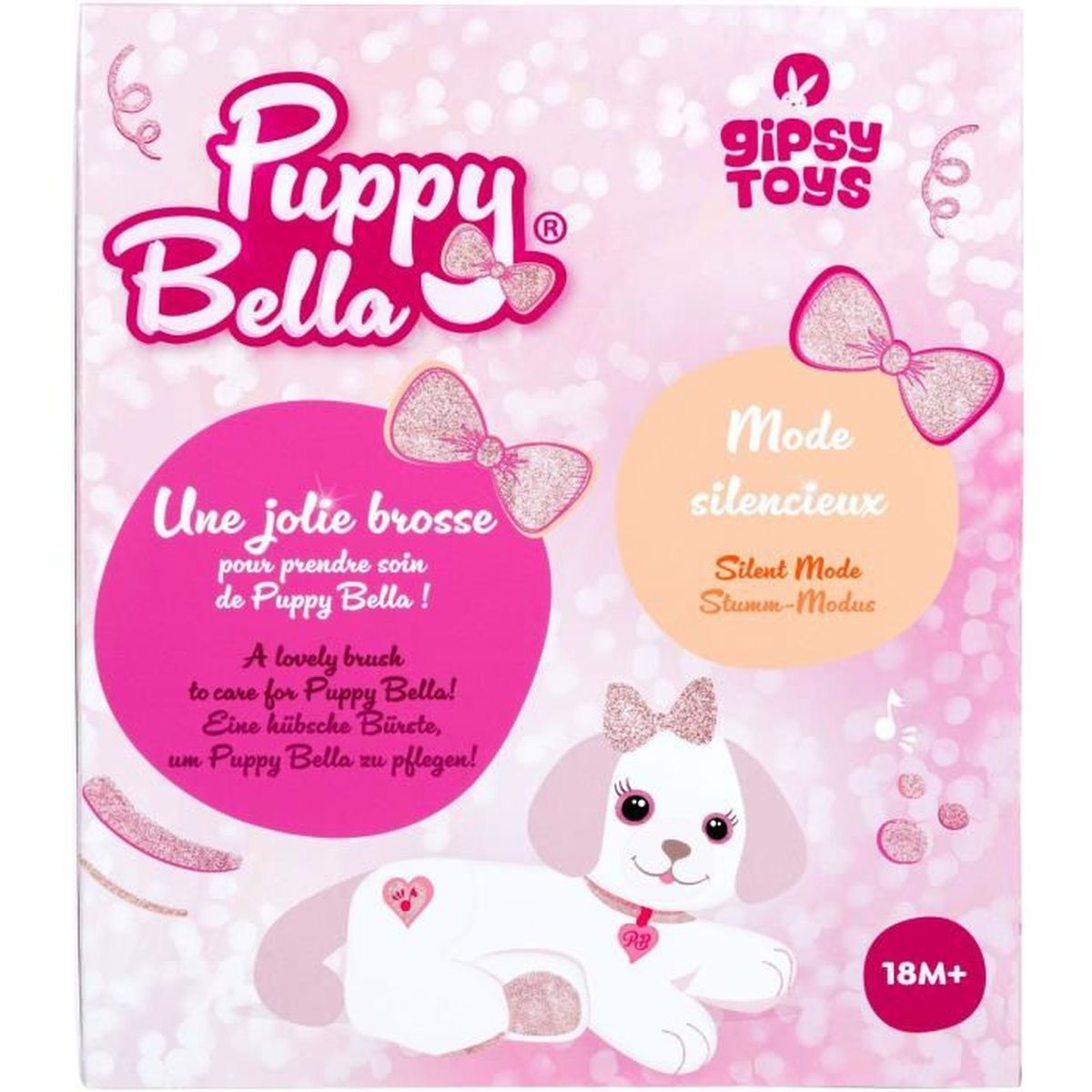 Une boîte de jouets Puppy Bella. Elle présente une illustration de chiot, des nœuds roses et du texte en plusieurs langues pour promouvoir le jouet.