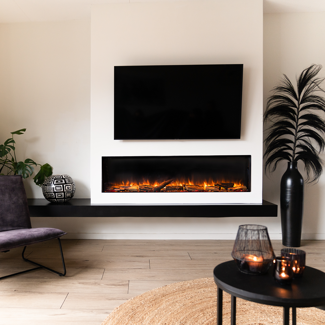 Een moderne woonkamer met open haard, tv en decoratieve items. Vuur aan, een zwarte vaas met plant en twee kandelaars.