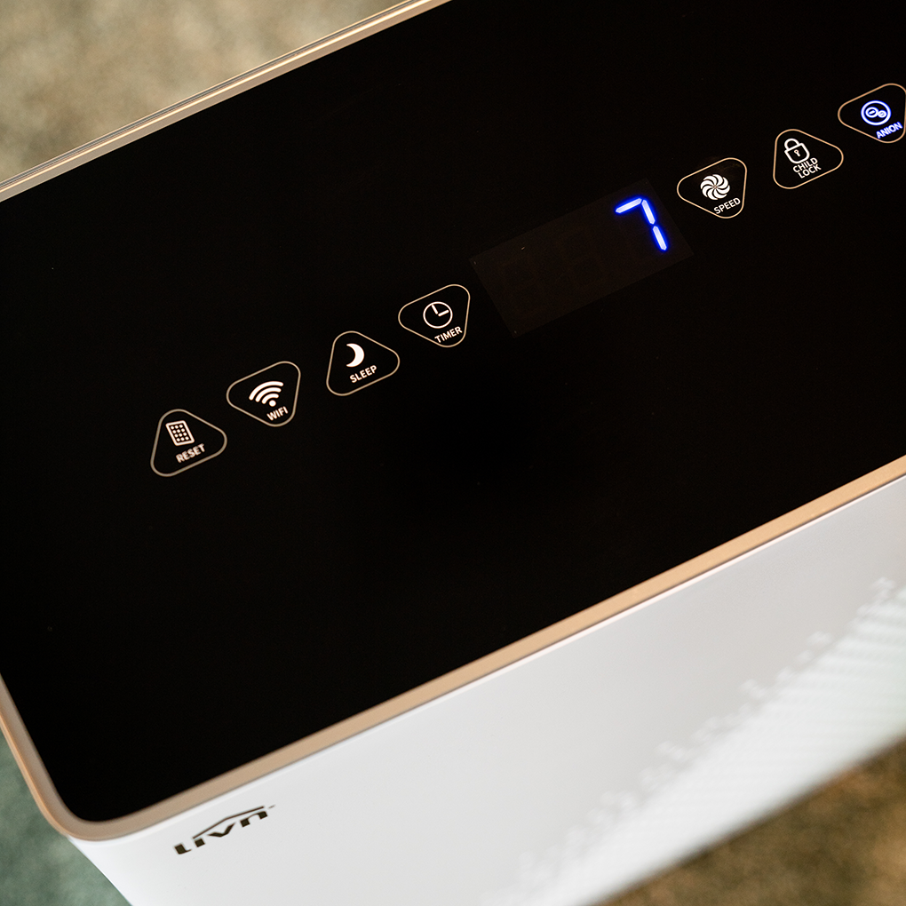 A close-up of an air purifier control panel. Buttons include reset, WiFi, sleep, timer, speed, child lock, and anion. The display shows the number 7.