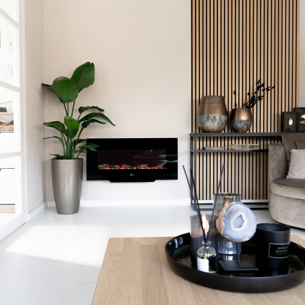 Living room with fireplace, plant, wooden panel wall, decorative items on a tray, and a cozy sofa.