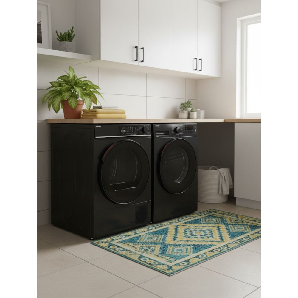 Een wasruimte met twee zwarte wasmachines, een vloerkleed, planten en witte kasten. Het vloerkleed is blauw en geel.