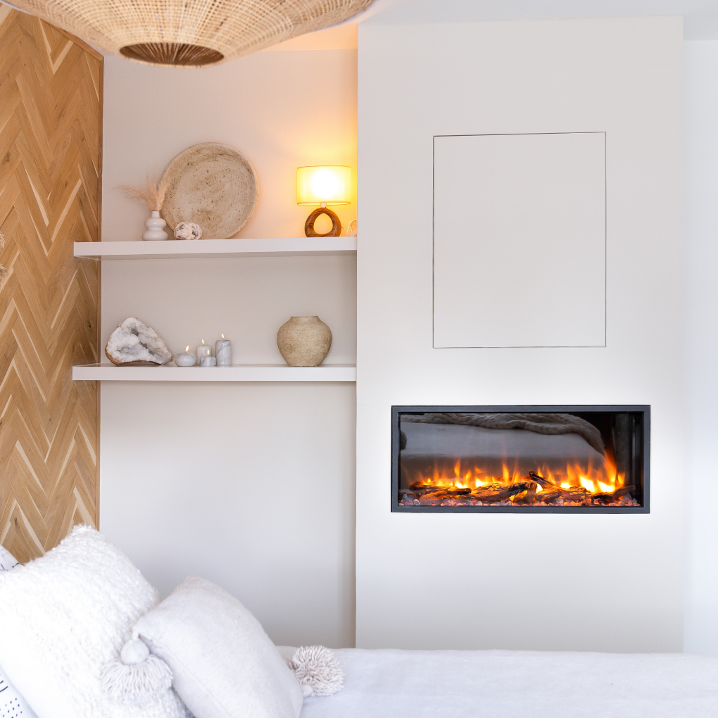 Een moderne woonkamer met een open haard, planken met decoratie en een bed met witte kussens.