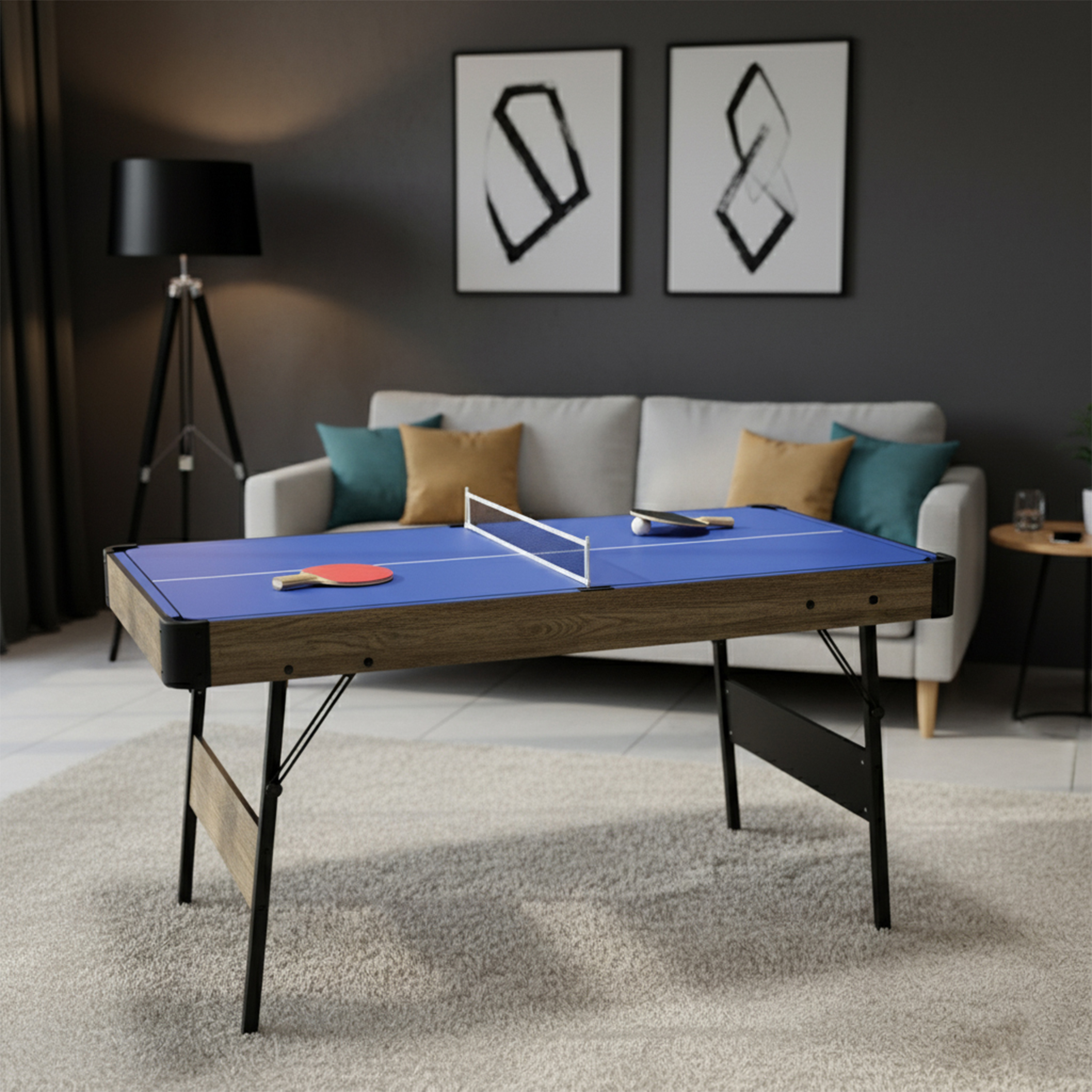 Ein Tischtennistisch in einem Wohnzimmer. Schläger und Ball liegen auf dem blauen Tisch. Sofa und Kunst im Hintergrund.