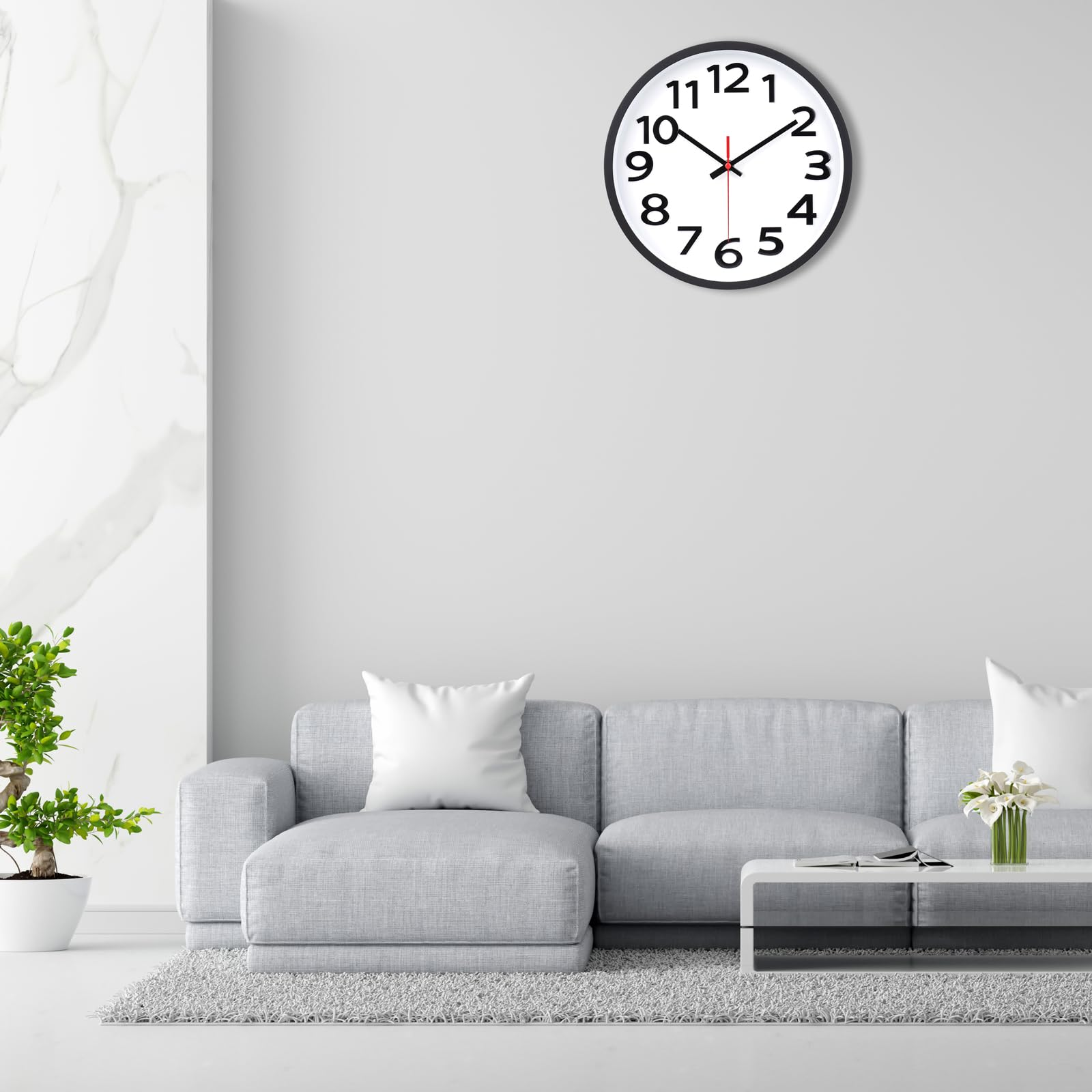 Ein modernes Wohnzimmer mit Uhr, grauem Sofa und kleinem Tisch mit Blumen.