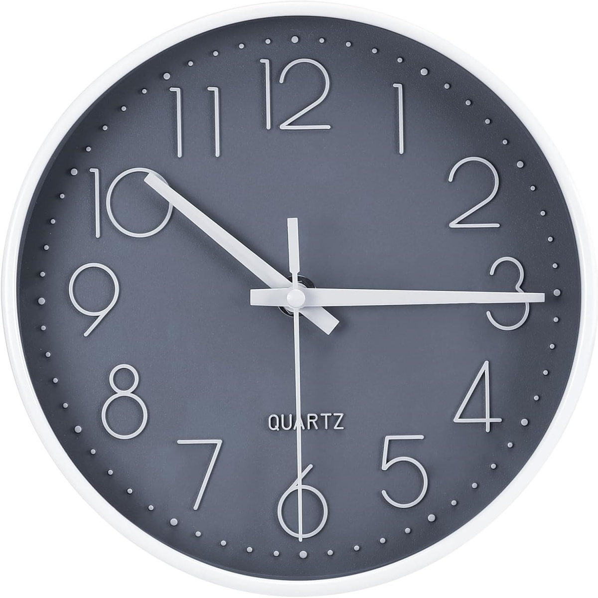 Eine runde Wanduhr mit weißem Rahmen. Das Zifferblatt ist grau mit weißen Zahlen und Zeigern. Es steht 'QUARTZ'.