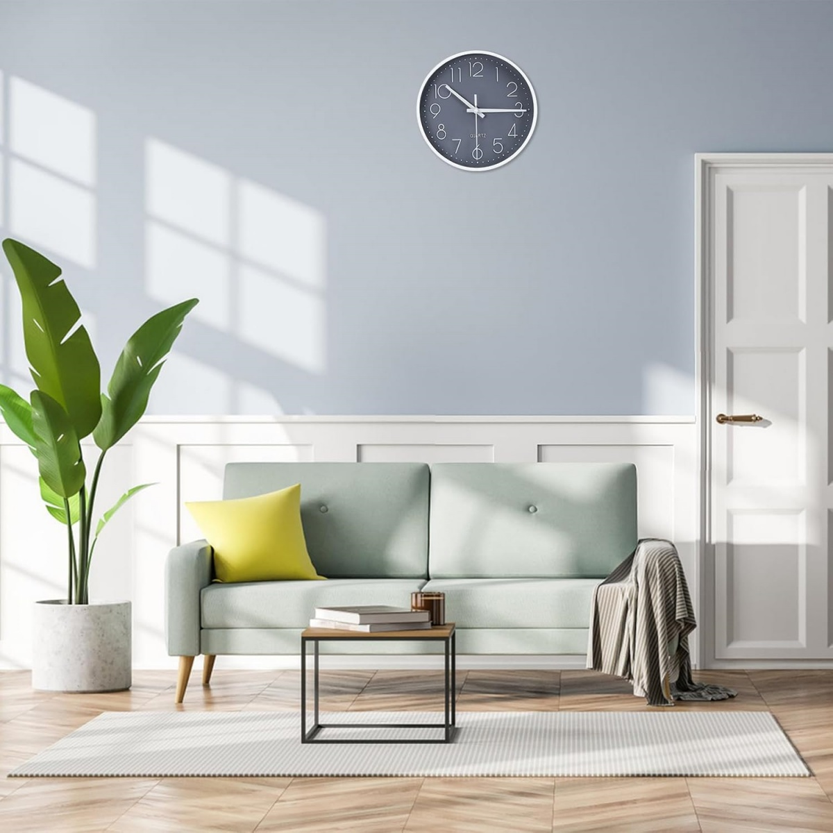 Wohnzimmer: Sofa, Uhr, Pflanze, Couchtisch, Teppich und Tür. Farben sind Blau, Grün und Gelb. Natürliches Licht von einem Fenster.
