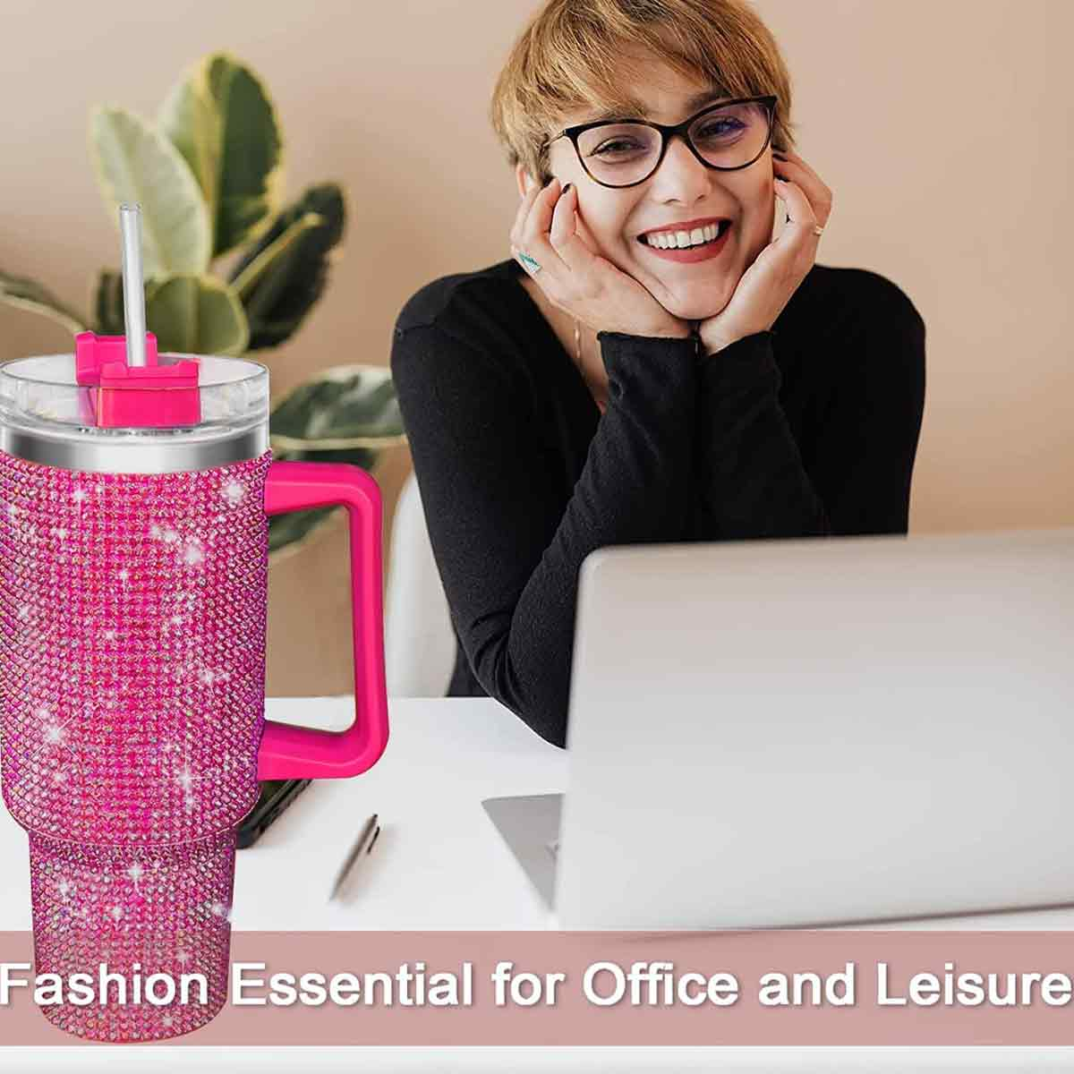 Eine lächelnde Frau neben einem pinkfarbenen, mit Strass besetzten Becher, einem Laptop und einem Stift. Text: Fashion Essential for Office and Leisure.