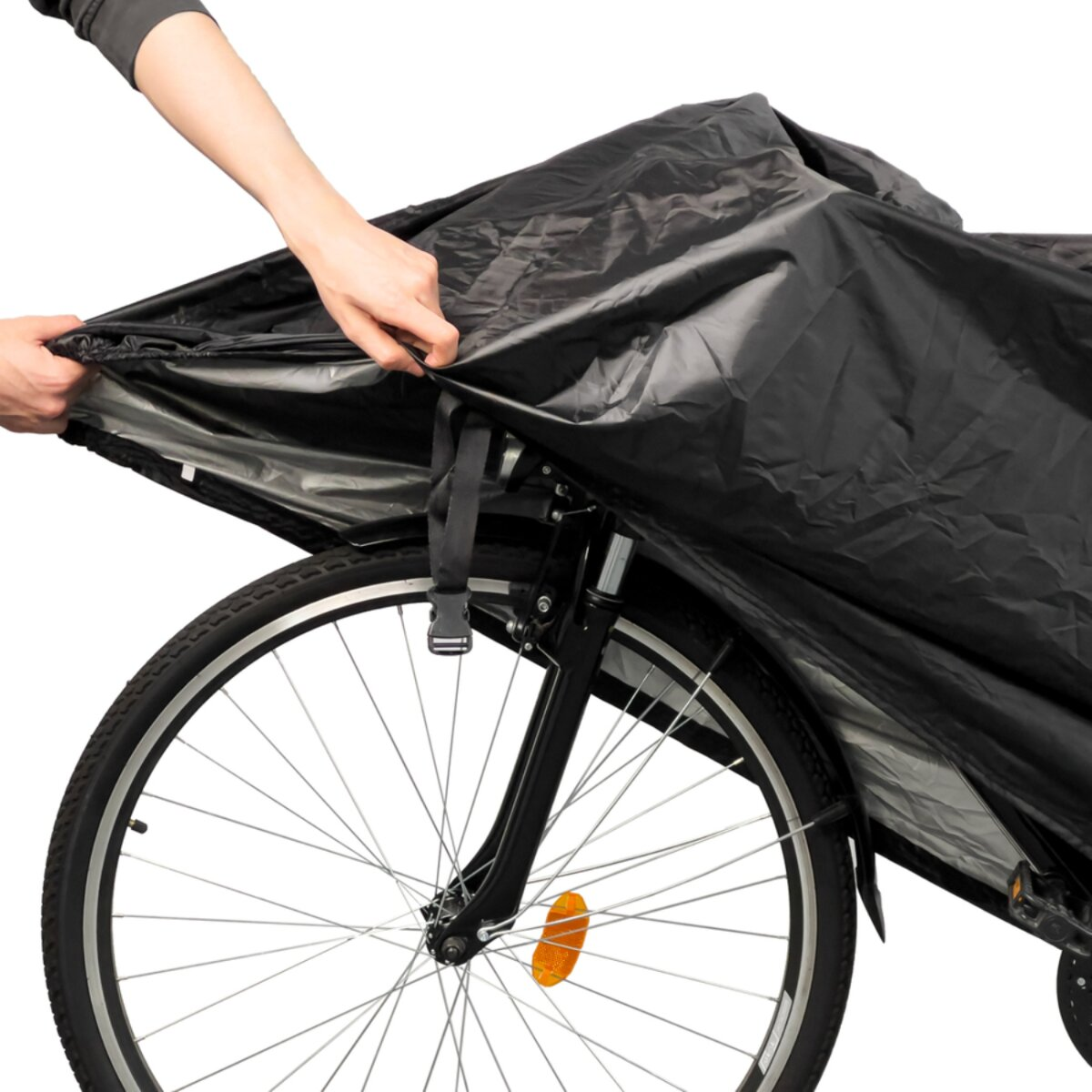 Die Hände einer Person bedecken ein schwarzes Fahrrad mit einer schwarzen Abdeckung. Der Reifen und der Kotflügel des Fahrrads sind sichtbar.