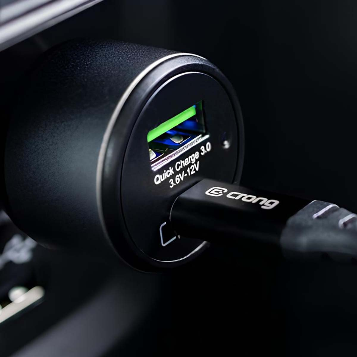 Nahaufnahme eines schwarzen Autoladegeräts mit USB-Anschluss. Ein schwarzes Ladekabel ist eingesteckt. Das Ladegerät hat 'Quick Charge 3.0'.