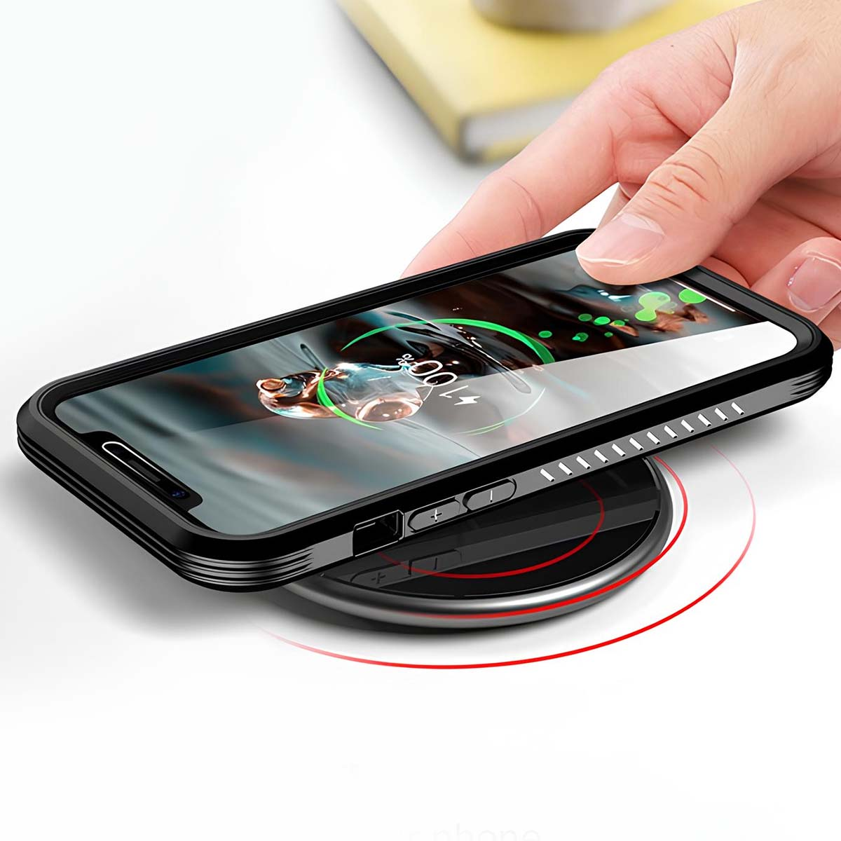 Eine Hand legt ein schwarzes Telefon mit Schutzhülle auf ein kabelloses Ladegerät. Der Bildschirm zeigt eine Ladeanimation.