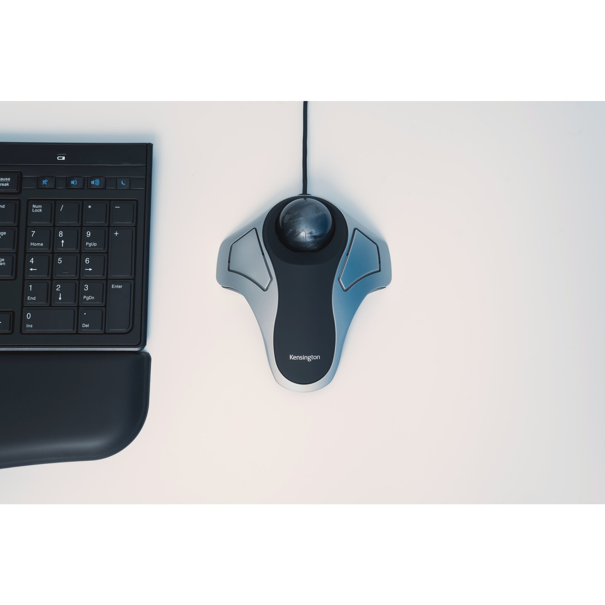A keyboard and a trackball mouse on a white surface. The mouse is a Kensington model. 