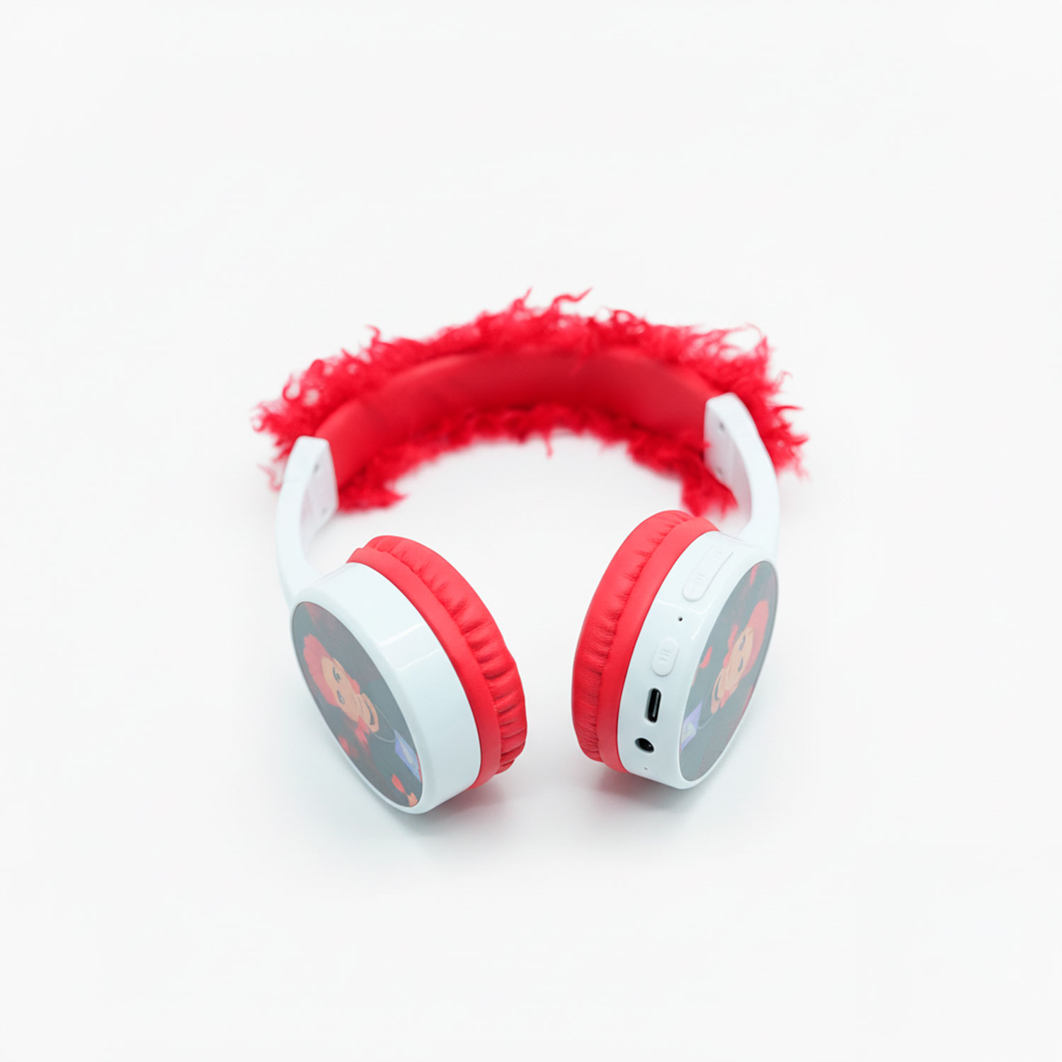 Cuffie rosse e bianche con archetto rosso e soffice. Ogni padiglione ha un'immagine a cartoni animati. Lo sfondo è bianco.