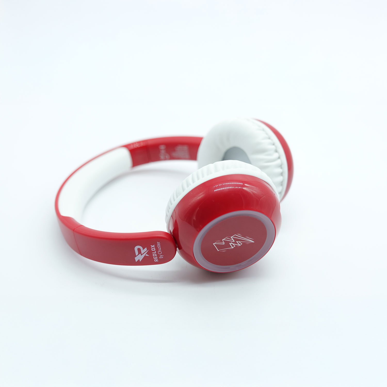 Cuffie rosse e bianche su sfondo bianco. Sono etichettate 'REDLOX by Chuster'. I padiglioni auricolari hanno un logo.
