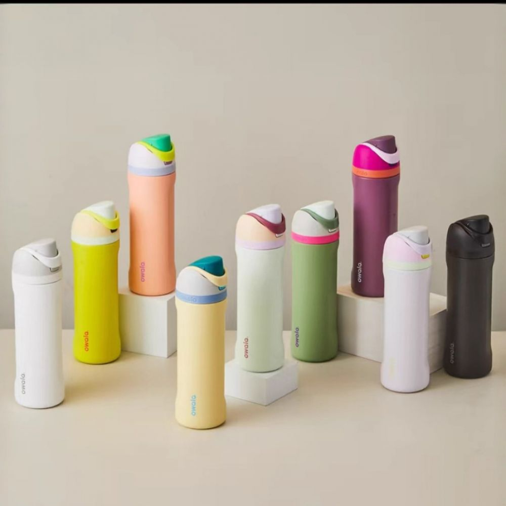 Neun bunte Owala-Wasserflaschen werden ausgestellt. Sie variieren in der Farbe, darunter Weiß, Gelb, Pfirsich, Grün, Lila und Schwarz.