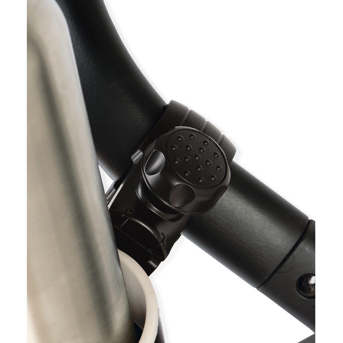 Nahaufnahme eines schwarzen, verstellbaren Knopfes an einer schwarzen Metallstange, in der Nähe einer silbernen Flasche. Der Hintergrund ist weiß.