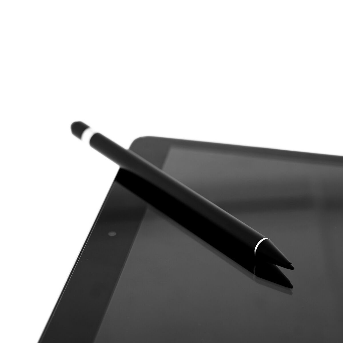 Ein schwarzer Stift liegt auf einem schwarzen Tablet. Der Stift hat einen weißen Akzent nahe der Spitze. Der Hintergrund ist weiß.